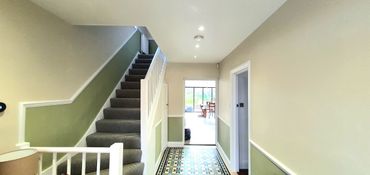 green and beige two tone walls with a dado rail dividing the hallway