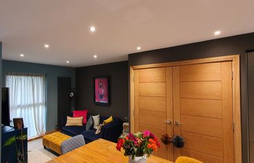 Open plan living room with bold colours. blues blacks, whites and vibrant natural oak