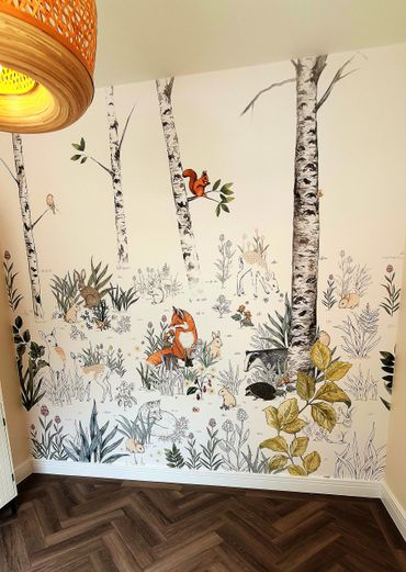 Decorative mural style wallpaper with a hand drawn style, includes a forest and wild animals. 