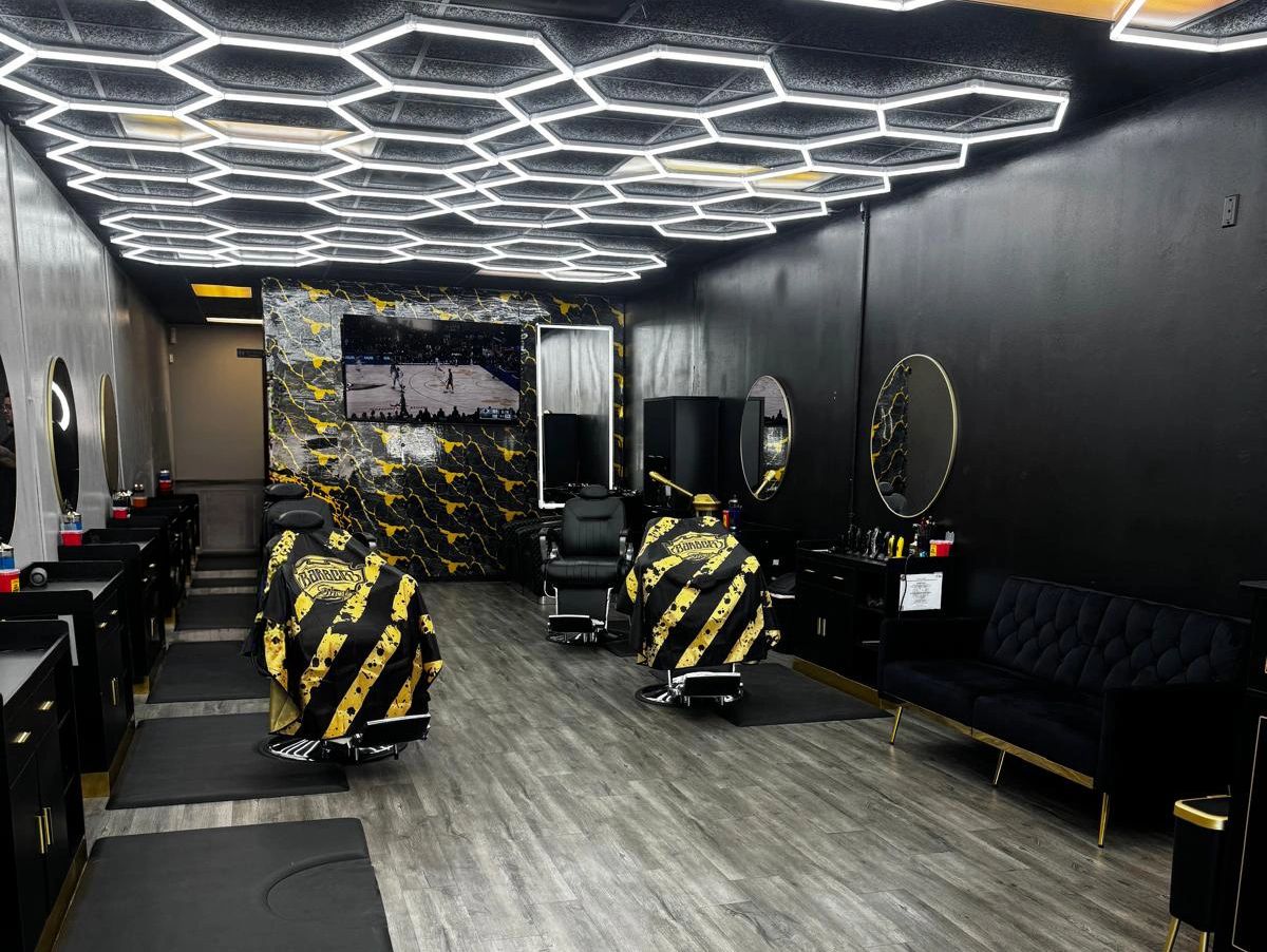 Modern barbershop with hexagonal ceiling lights and black-yellow decor.