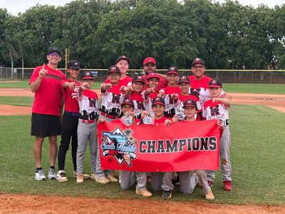 Youth baseball team celebrating a championship with Coach Ray 
