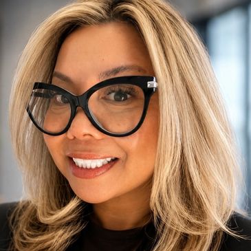 Smiling woman with blonde hair and large black glasses.