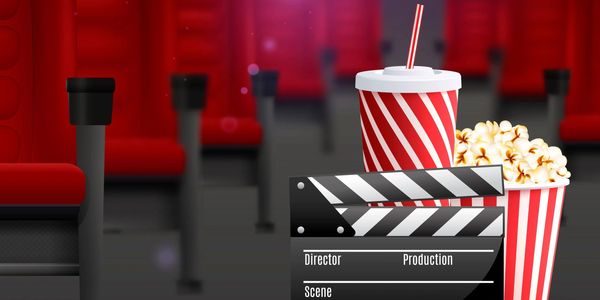 Movie theater setup with popcorn, drink, and clapperboard in front of red seats.