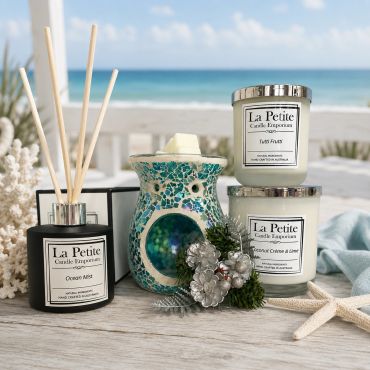 Beach-themed candles and diffuser with decorative pinecones.