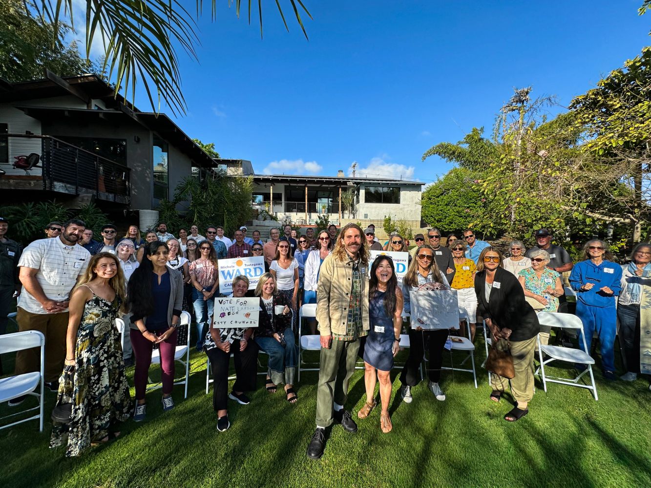Group of local community members gathered outdoors at a North County campaign event.