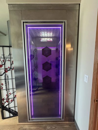 Modern whole body cryotherapy chamber with purple LED lights and sleek design.