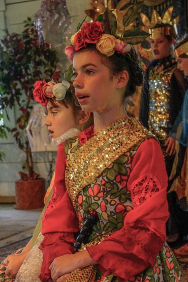 Two girls in floral, sequined costumes with flower crowns.