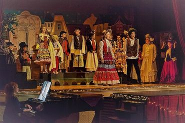 Children performing a stage play in traditional costumes.