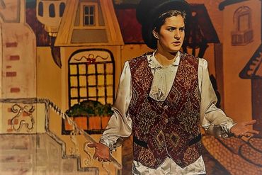 Person in vintage attire with expressive gesture.