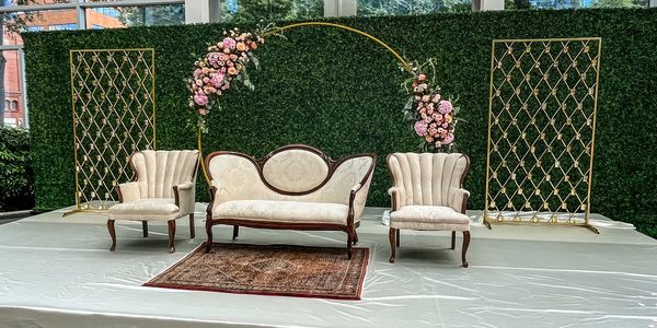 Elegant vintage seating setup with floral arch for a special event.