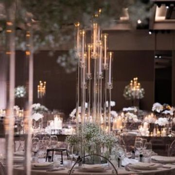 Elegant restaurant table setting with tall candle centerpiece.
