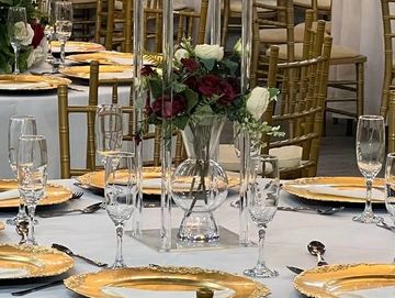 Elegant banquet tables with floral centerpieces and gold-accented tableware.
