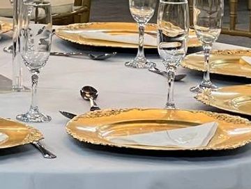 Elegant banquet tables with floral centerpieces and gold-accented tableware.