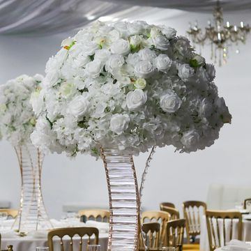 Elegant wedding reception with white floral centerpieces and gold chairs.