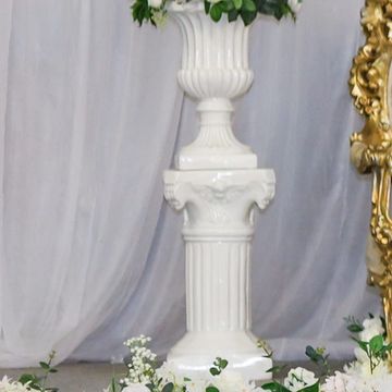 Elegant wedding stage with gold chairs and white floral decorations.
