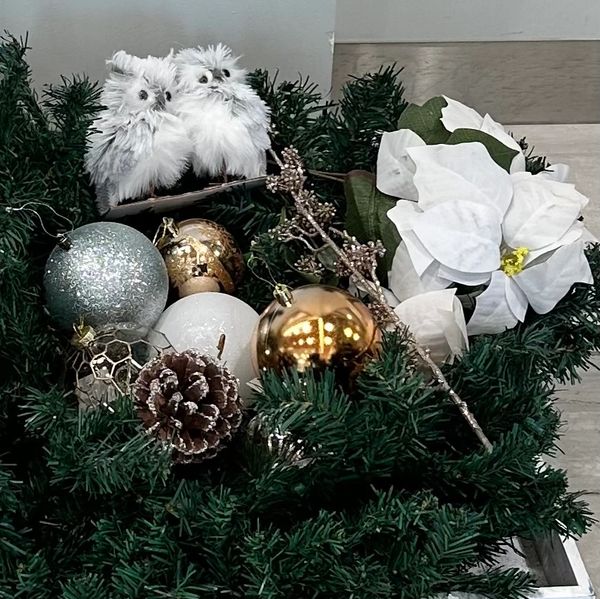 Festive Christmas wreath with white owls, ornaments, and poinsettia flowers.