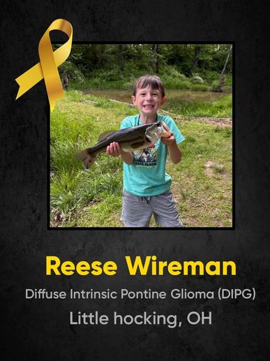 Young boy holding a fish with a yellow awareness ribbon.