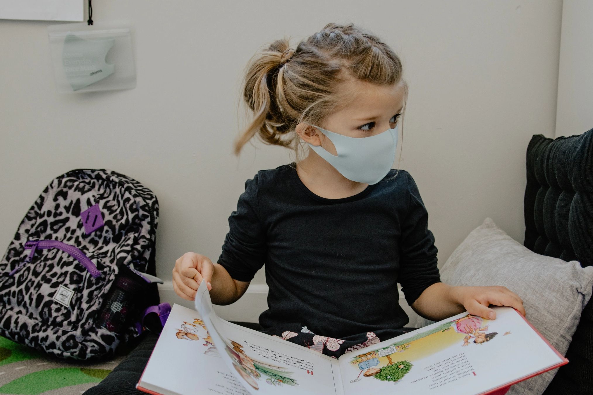 Young girl with mask reading