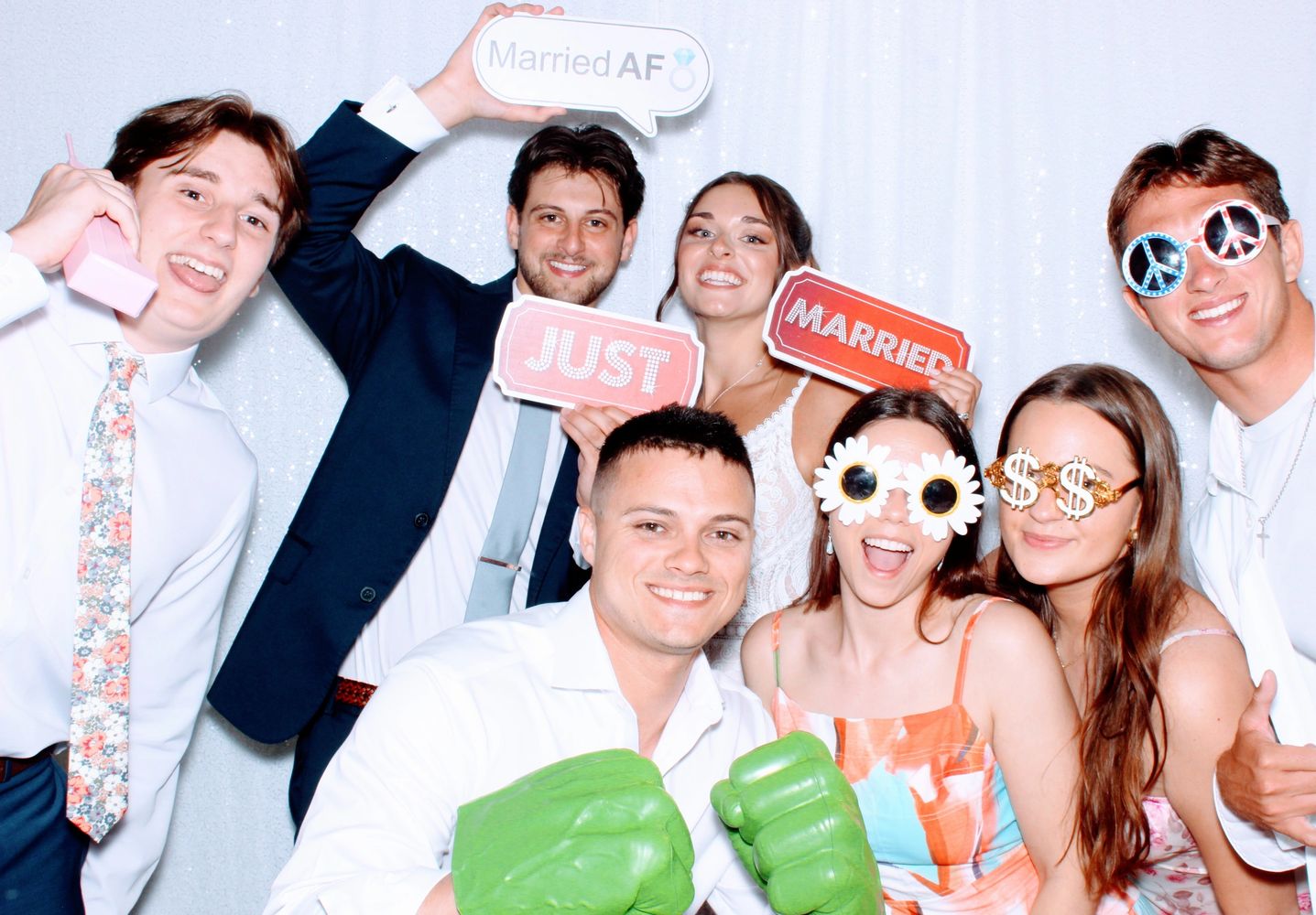 group of people at wedding laughing and having fun in a photo booth