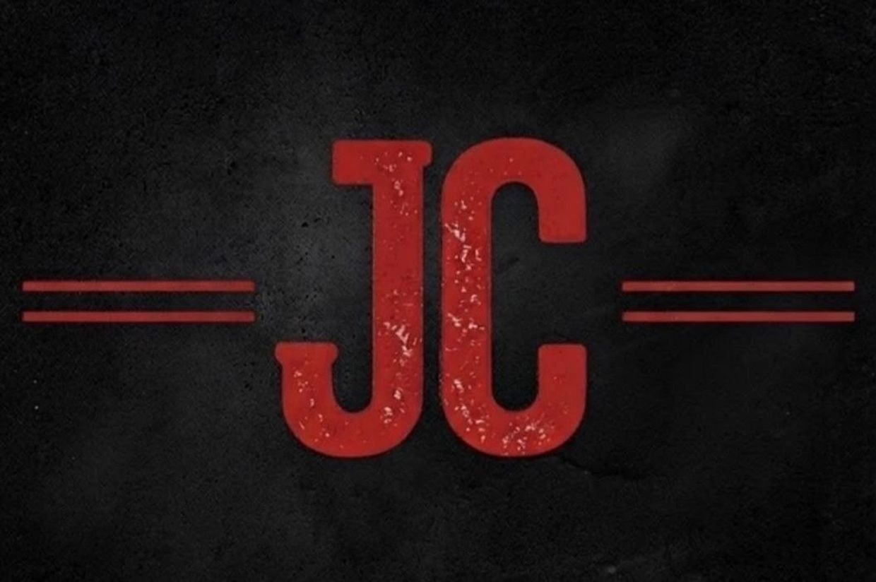 Logo rojo de JC sobre fondo negro.