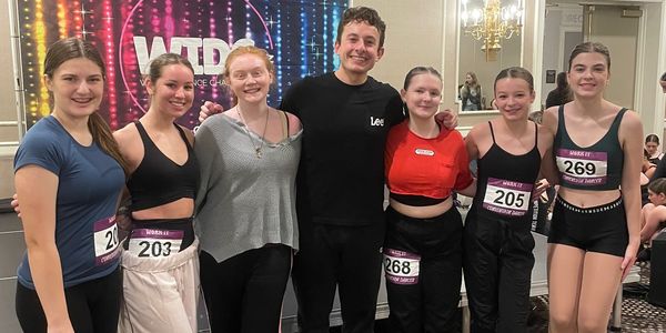 Group of young dancers posing together at a dance event.