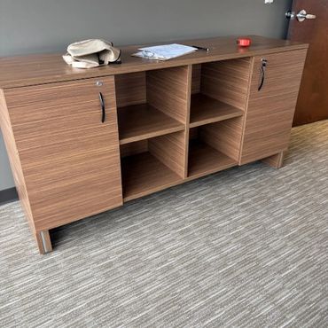 Wooden cabinet with shelves and doors in an office.