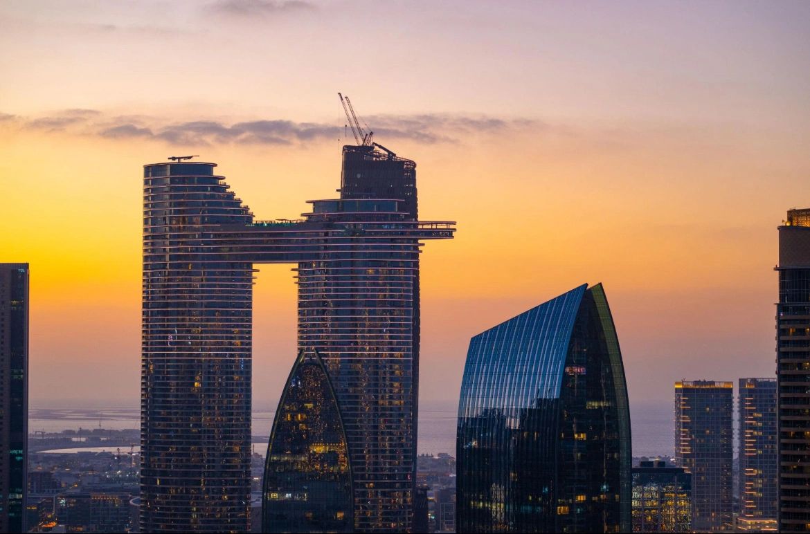 Modern skyscrapers at sunset with a golden sky background.
