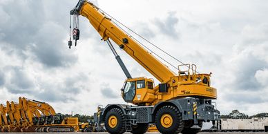 A large yellow construction crane under a cloudy sky.