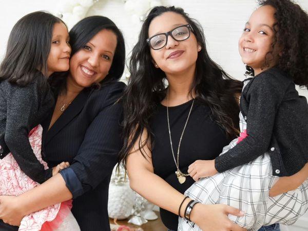 Two women with two girls smiling at the camera