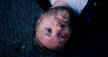 man lying in pain, deep in thought