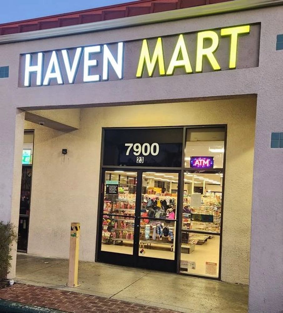 Entrance of Haven Mart convenience store at dusk with illuminated signage.