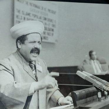 Man passionately speaking at a podium during a formal event.