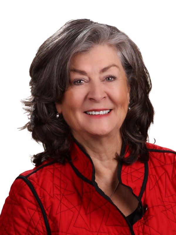 Smiling woman with gray hair in a red jacket.