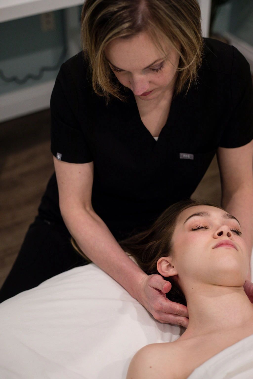 A therapist delivers a neck massage to the client