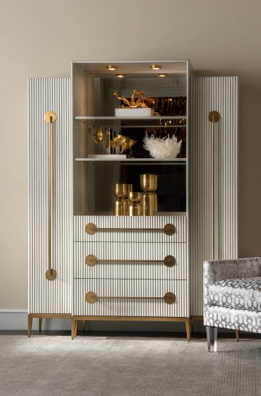 Elegant white cabinet with gold accents and decorative items inside.