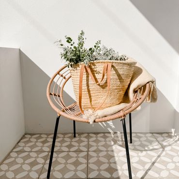 Flowers in basket on sunny balcony