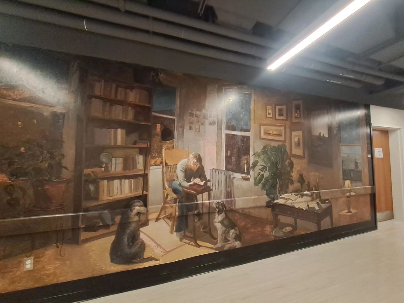 Mural of a person reading with two dogs in a cozy room.