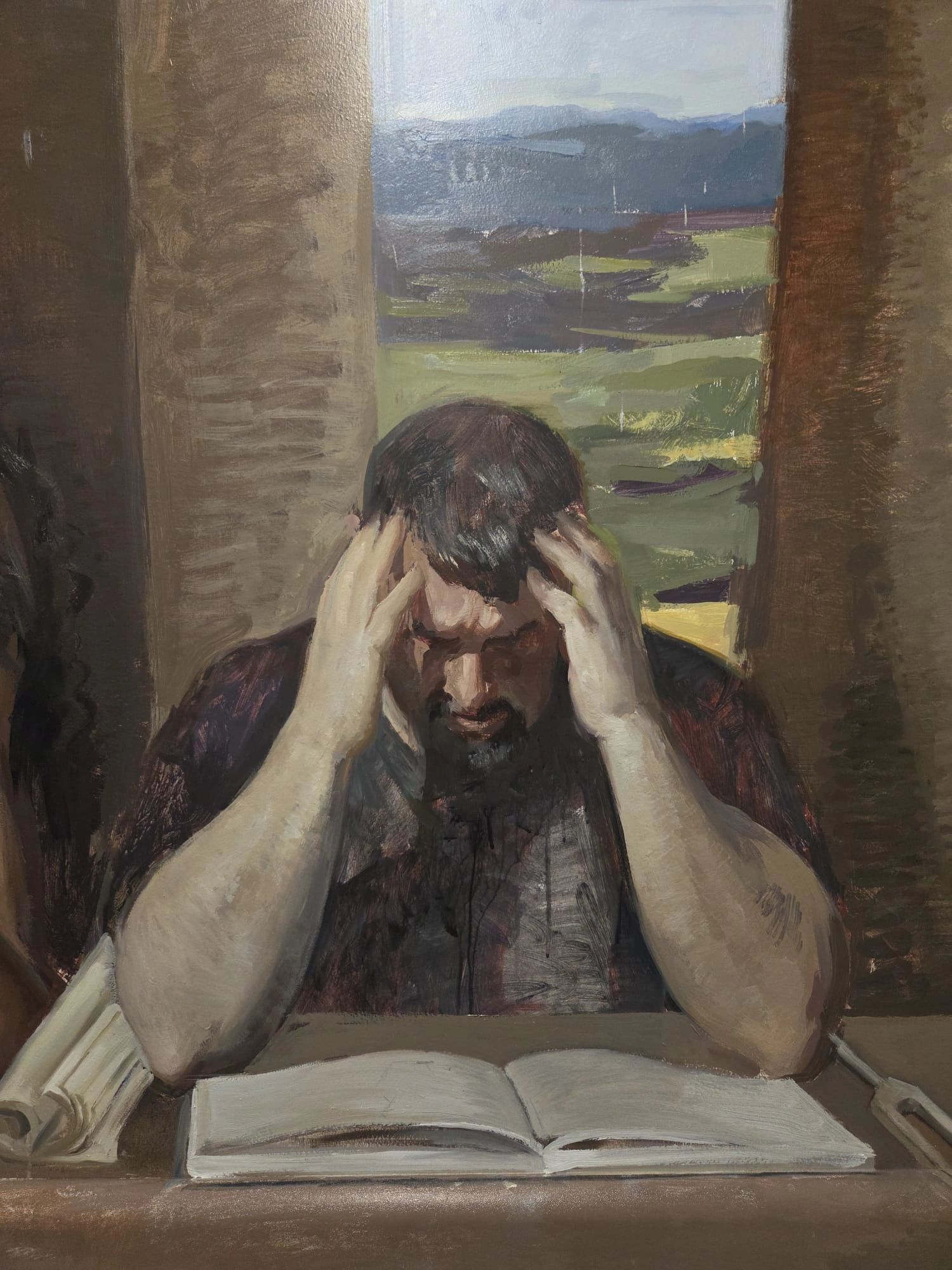 Man overwhelmed while reading a book by a window.