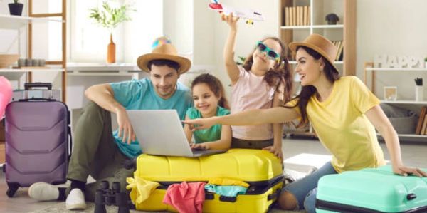 Family packing suitcases and planning trip together at home.