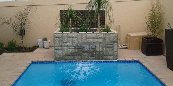 Swimming pool with concrete flower bed water feature