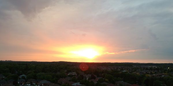 Sunset over a residential area with clouds.