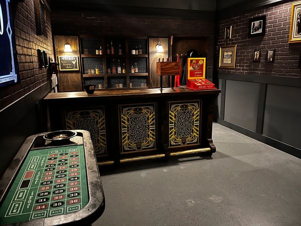 Vintage casino room with roulette table and decorative bar counter.