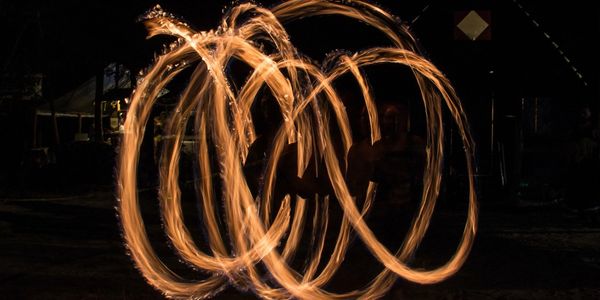Fire dancing creating bright, swirling patterns in the dark.