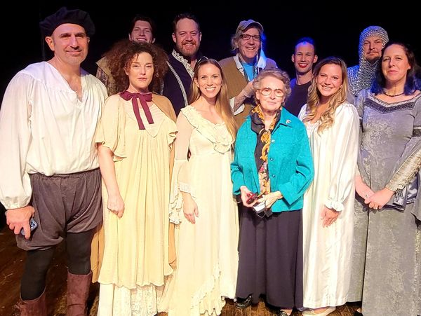Group of people in theatrical costumes posing for a photo.