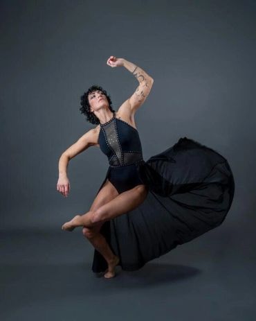 Dancer in black outfit striking a graceful pose.