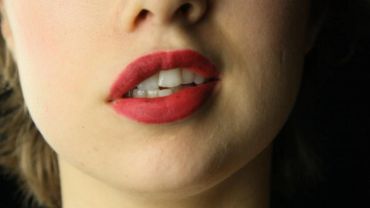 Close-up of lips with red lipstick.