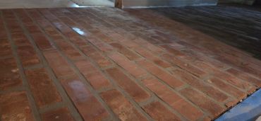Close-up of a brick floor inside a room.