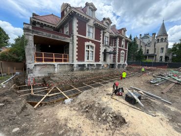 Construction site in front of an old mansion.