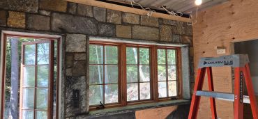 Stone wall interior with windows and a ladder.