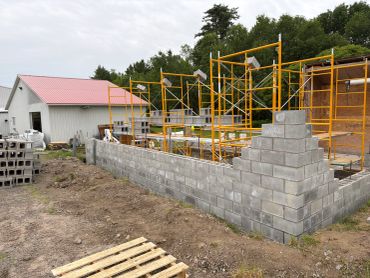 Construction site with concrete block wall and scaffolding.